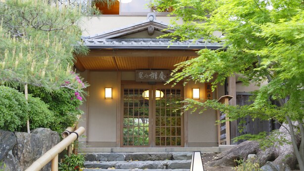 A traditional Japanese building with a wooden entrance, stone steps, and a sign above the door. - Arashiyama Benkei (Kyoto)