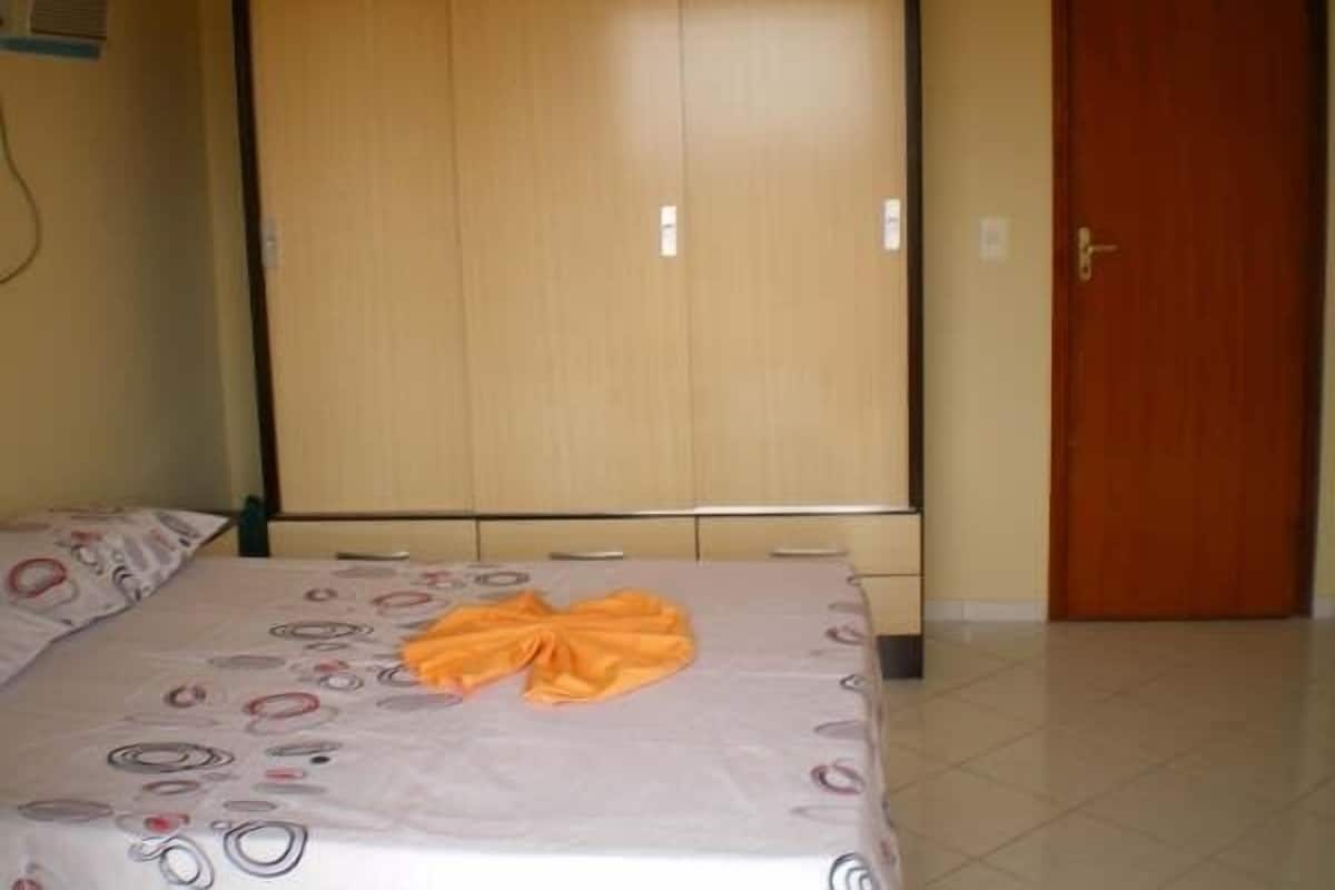 Een slaapkamer met een bed, een kledingkast en een deur.