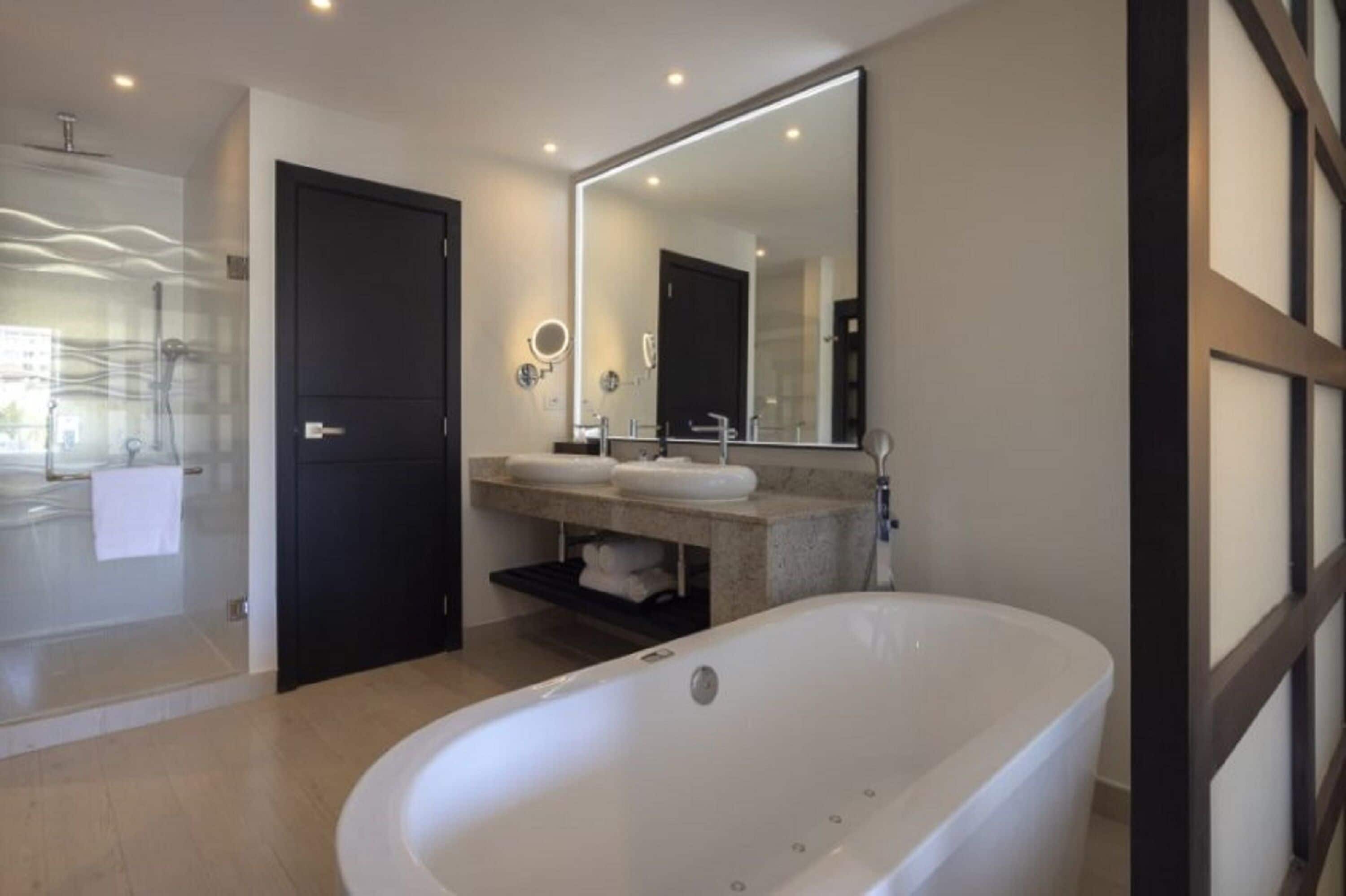 Une salle de bain moderne avec une baignoire sur pieds, un grand miroir et une cabine de douche en verre.