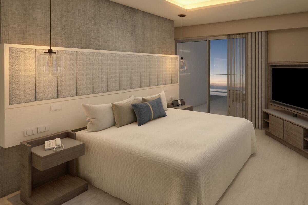 A modern hotel room with a large bed, a TV, and a balcony with a city view.