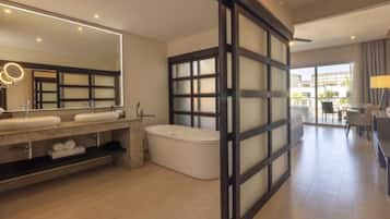 Um banheiro moderno com um espelho grande, duas pias, uma banheira e uma porta de vidro corrediça para uma varanda.