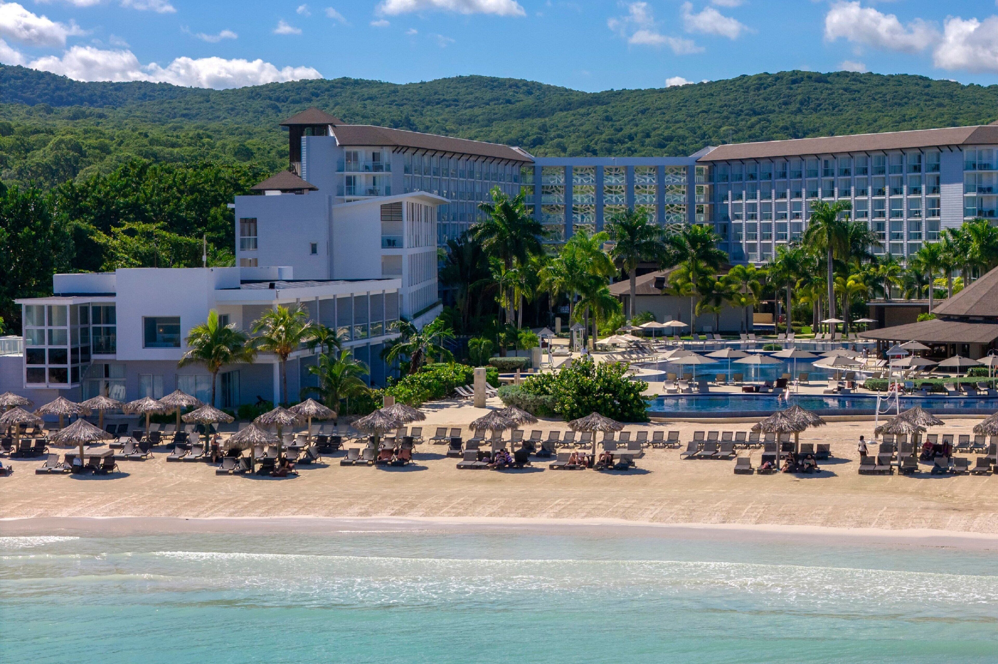 A resort with a pool, beach, and multiple buildings.