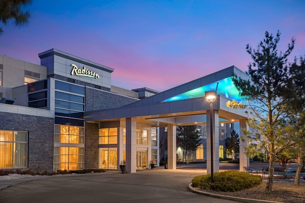 A Radisson hotel with a modern facade, large windows, and a covered entrance area.