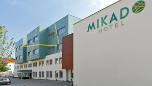 Egy modern szállodai épület, amelyen egy „MIKAD HOTEL” feliratú tábla látható.