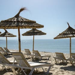 På stranden, solstolar, parasoller och strandhanddukar