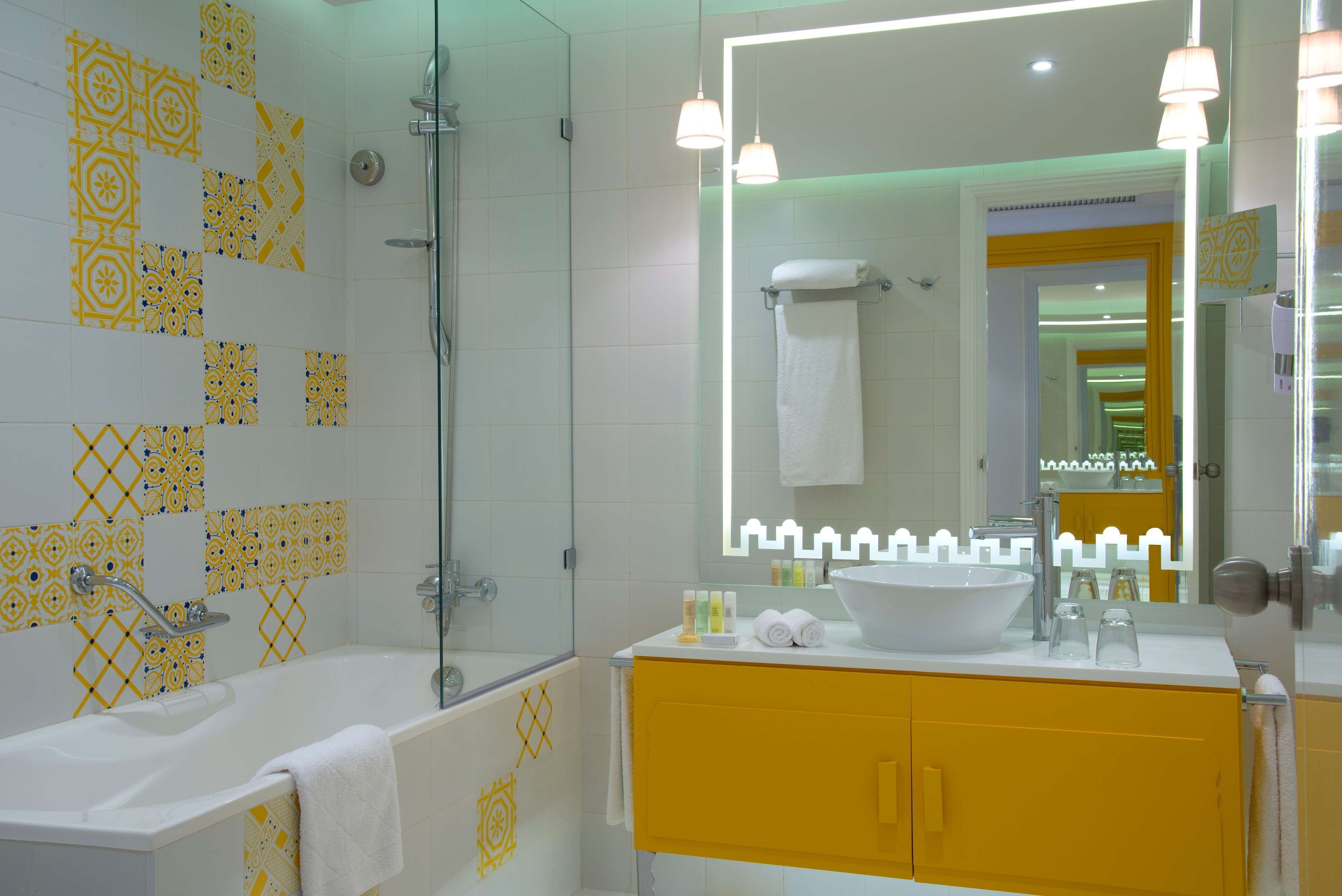A bathroom with a bathtub, a sink, and a mirror.