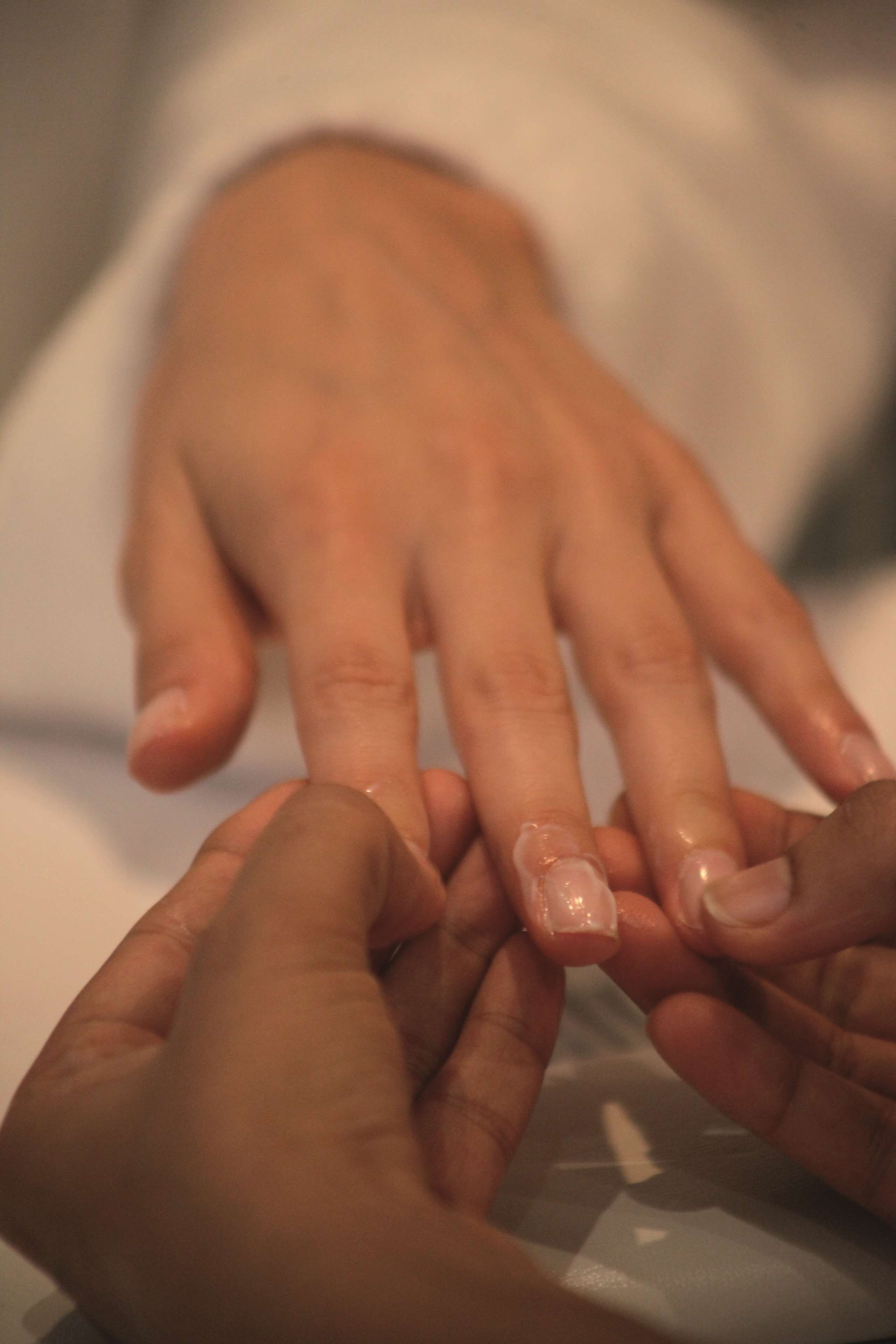 A close-up of hands, one with a bandaged finger.