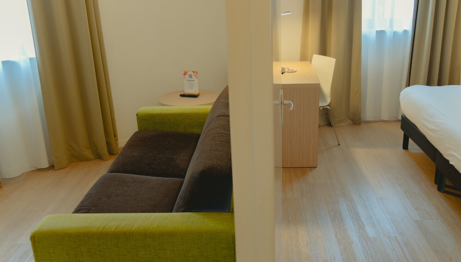 Une chambre d’hôtel avec un lit, un bureau, une chaise et un canapé.