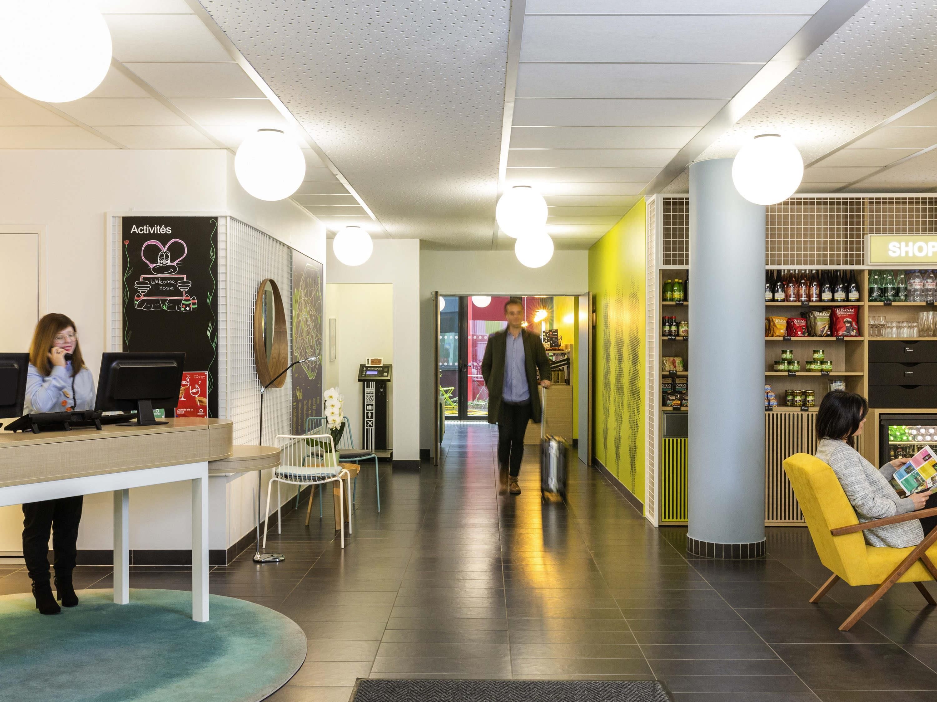 A reception area with a desk, chairs, a counter, and a wall with a 'Welcome Home' sign.