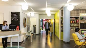 A reception area with a desk, chairs, a counter, and a wall with a 'Welcome Home' sign.
