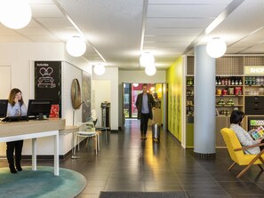 A reception area with a desk, chairs, a counter, and a wall with a 'Welcome Home' sign. - Aparthotel Adagio Access Paris Reuilly (Paris)