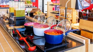A buffet setup with various food items and cooking stations. - ibis Ourinhos (Ourinhos)