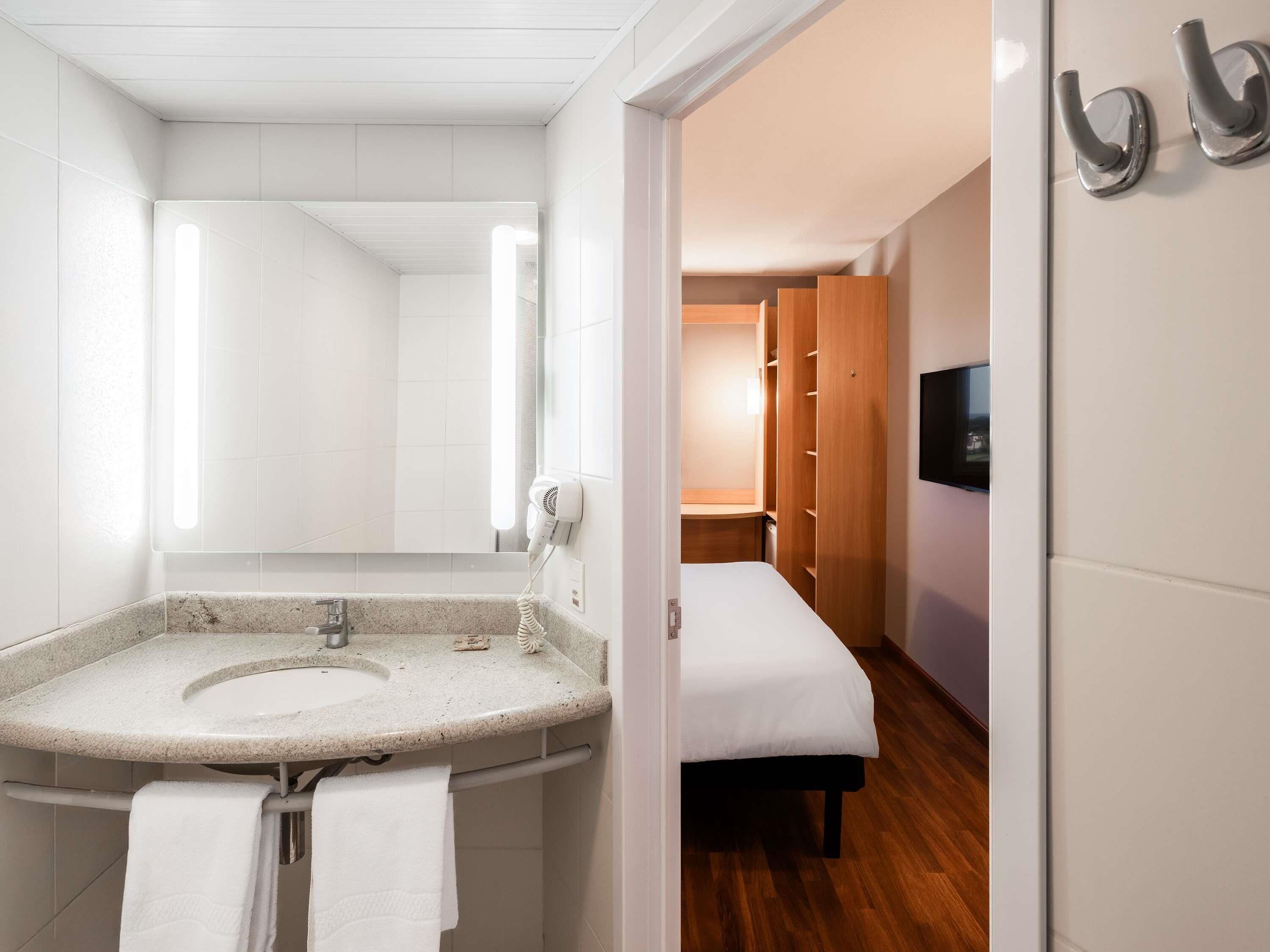 Une salle de bain équipée d’un lavabo en granit, d’un sèche-cheveux et d’un porte-serviettes.