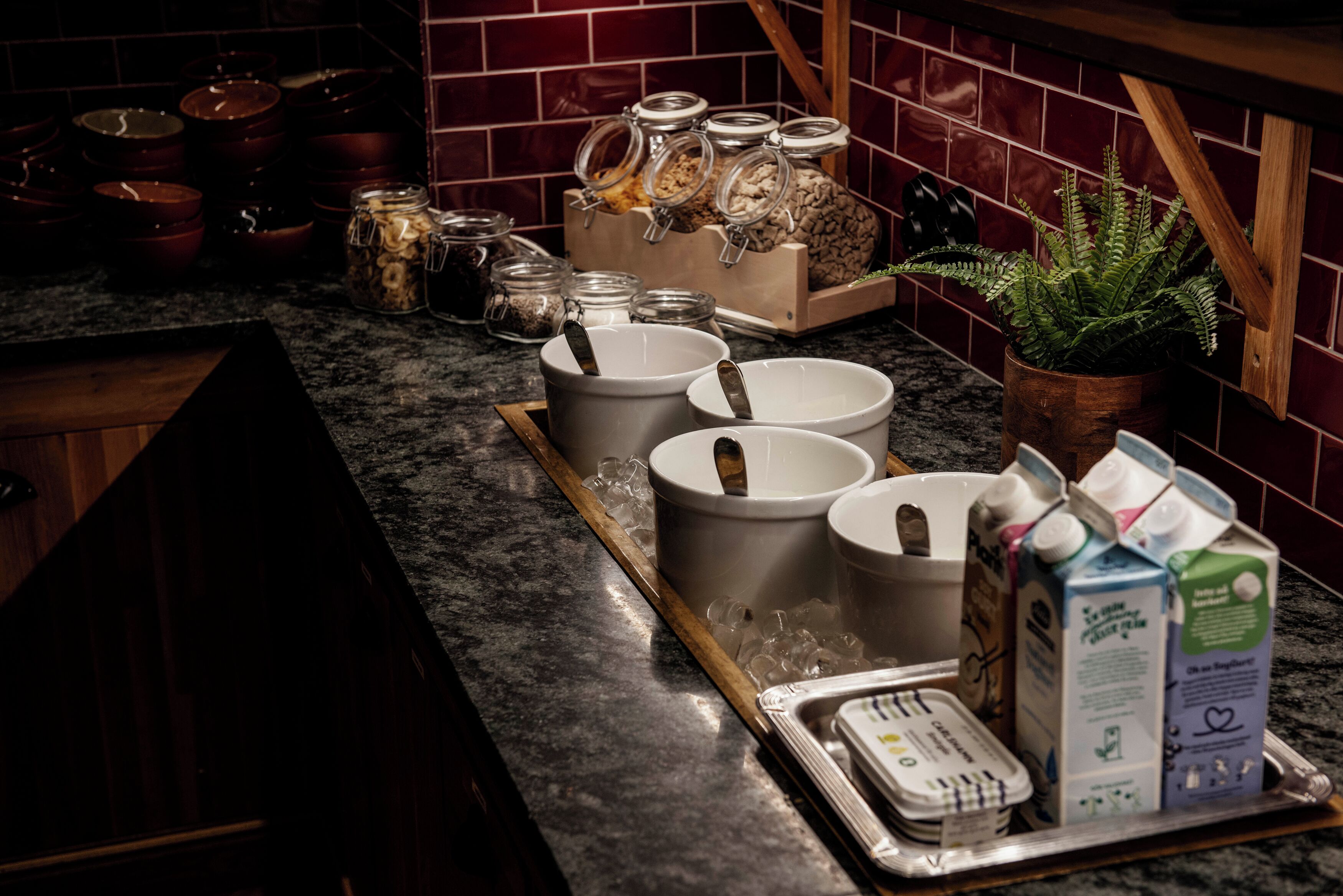 A kitchen counter with various containers, bowls, and a tray with food items.