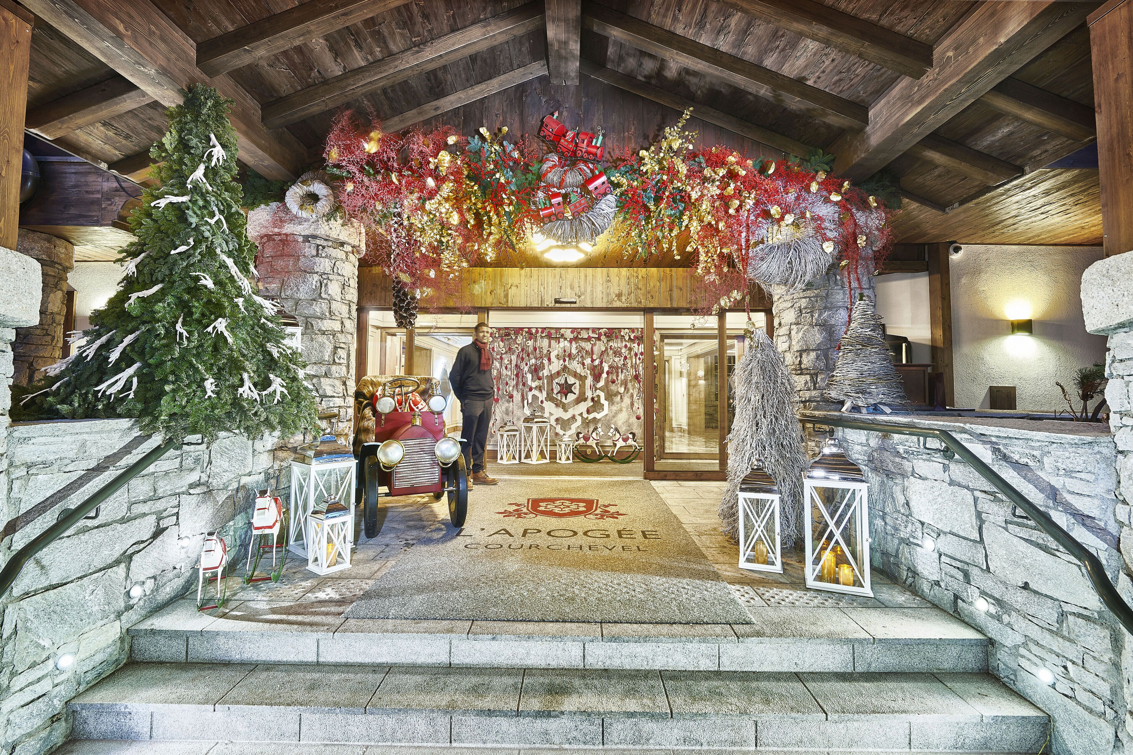 Un majestuoso acceso con una escalera de piedra, un árbol de Navidad y decoraciones festivas.