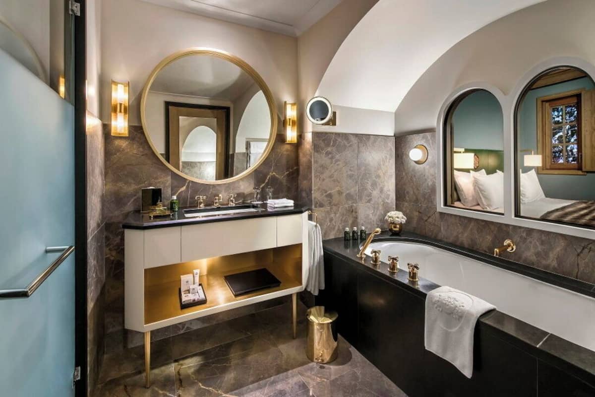 Ein modernes Badezimmer mit Waschtisch, einer Badewanne und zwei großen Spiegeln.