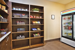 A hotel room with a snack shelf stocked with various items and a beverage refrigerator. - Holiday Inn Express Hastings by IHG (Hastings)