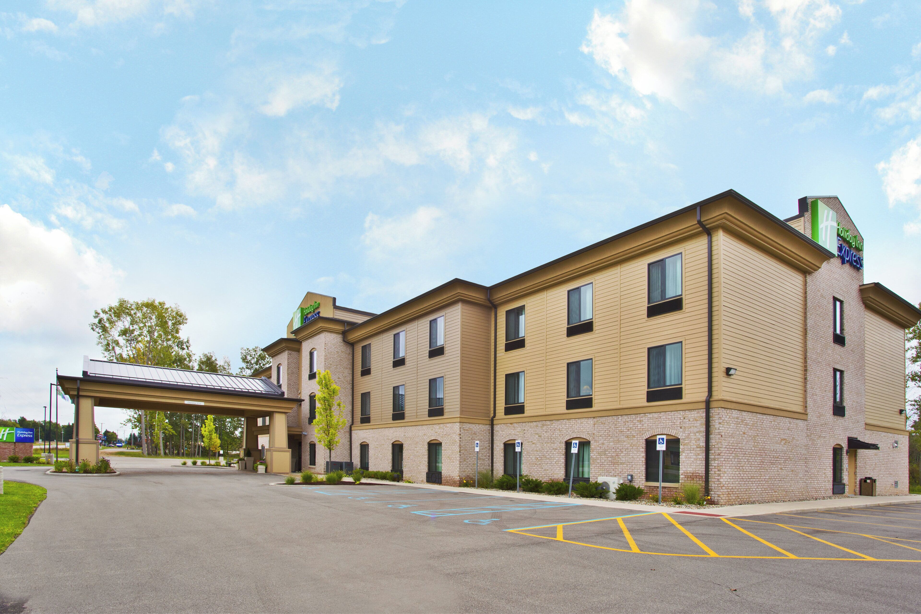 A Holiday Inn Express hotel with a covered entrance, parking lot, and brick facade.