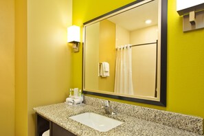 A bathroom with a granite countertop, a white sink, a large mirror, and a shower curtain. - Holiday Inn Express Hastings by IHG (Hastings)