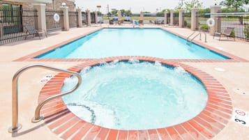 A rectangular swimming pool with a hot tub in the foreground.