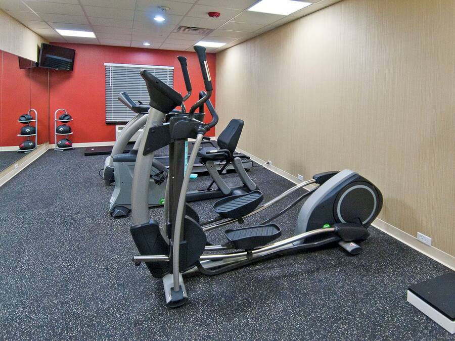 Ein Fitnessstudio mit Laufbändern, Gewichten und einer Steplatform.