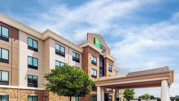 Un hotel Holiday Inn Express amb façana de maó, nombroses finestres i una zona d'entrada coberta.