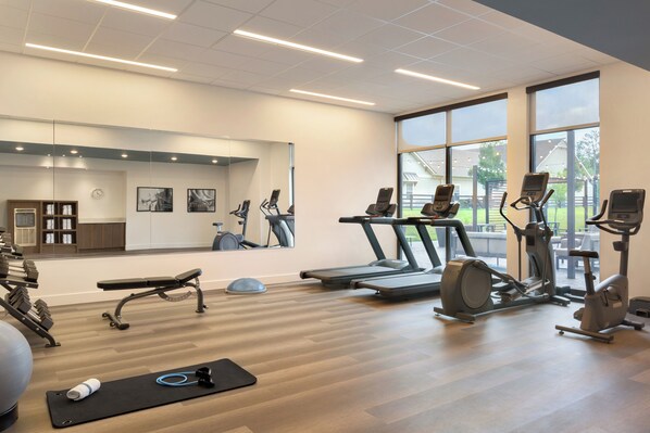 A gym with exercise equipment, a mirror, and large windows. - Staybridge Suites Atlanta Airport by IHG (Atlanta)