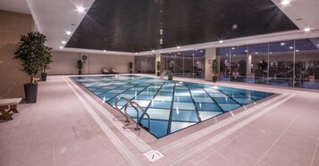 Una piscina techada, sillones reclinables de piscina