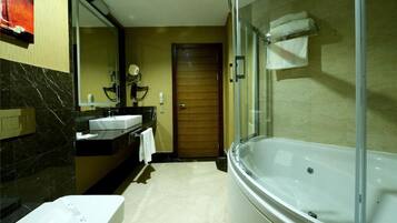 Un baño moderno con ducha envuelta en vidrio, una bañera independiente y un lavamanos con espejo.