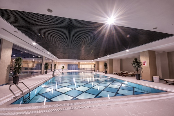 Una piscina techada, sillones reclinables de piscina