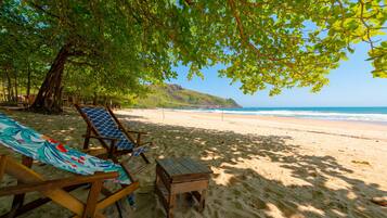 Na praia, areia branca, espreguiçadeiras, prática de mergulho autônomo