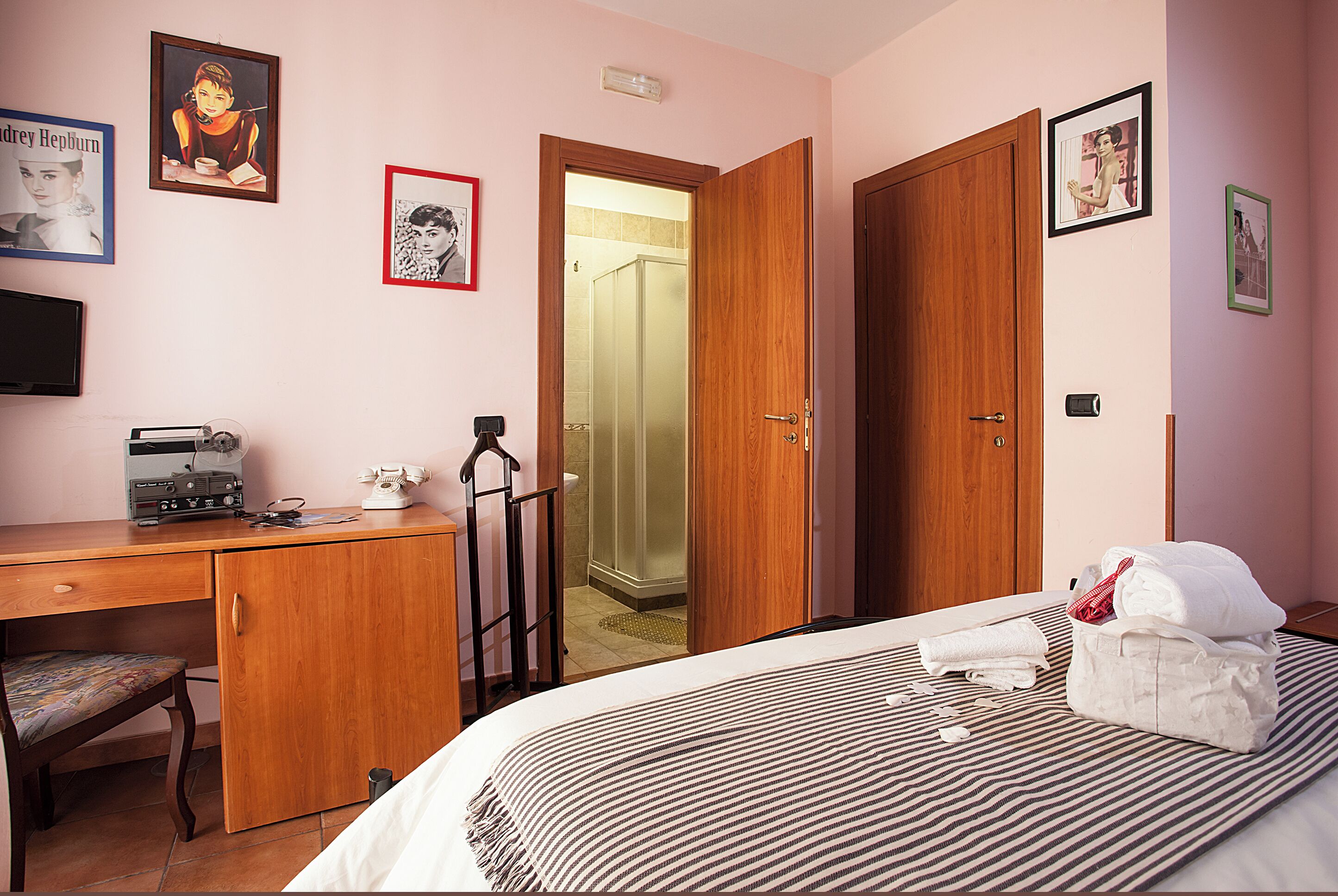A bedroom with a bed, a desk, a chair, and a wardrobe.
