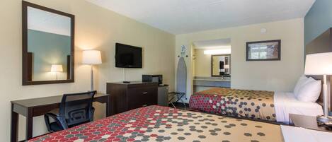 Une chambre d’hôtel avec deux lits, un bureau, une chaise, une télévision et un miroir.