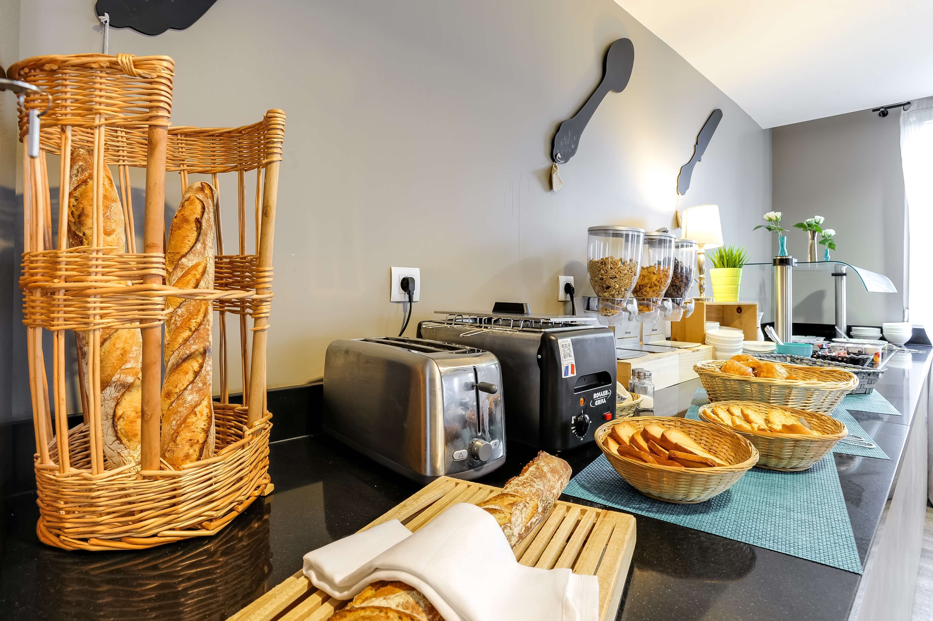 Una cocina con una cesta de mimbre para pan, dos tostadoras y una cafetera.