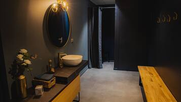 A modern bathroom with a vanity, sink, and mirror.