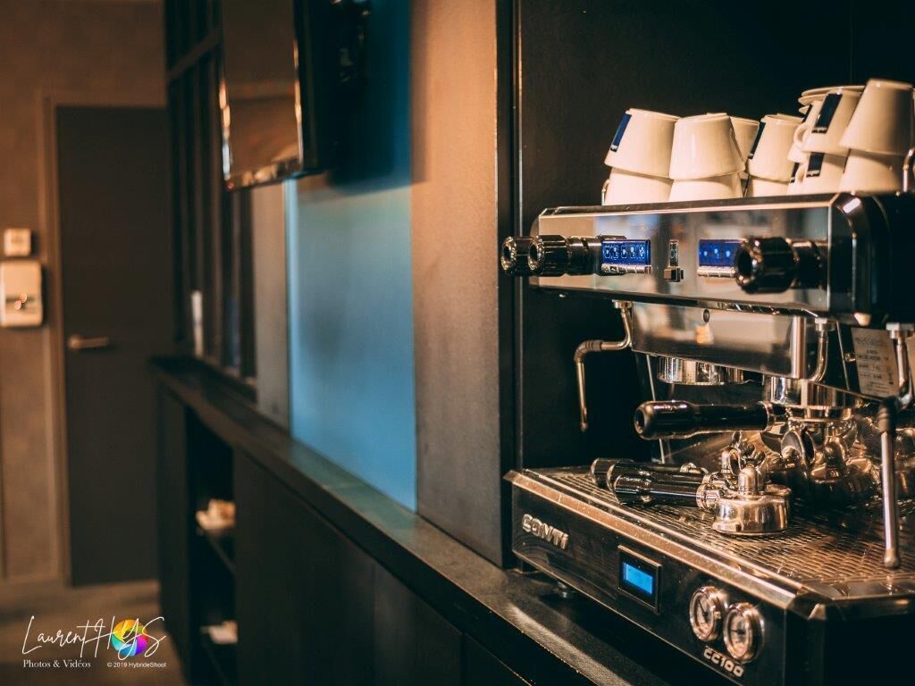 A commercial espresso machine with multiple coffee dispensers and a digital display, likely in a cafe or restaurant setting.