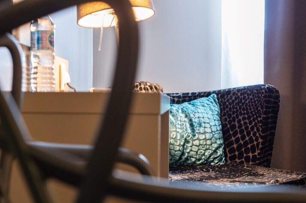A room with a sofa, a lamp, and a water bottle on a table.