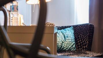 A room with a sofa, a lamp, and a water bottle on a table.