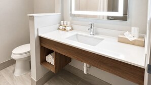 A modern bathroom with a white sink, mirror, and toilet. - Holiday Inn Express Kenedy by IHG (Kenedy)