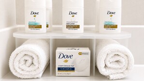 A bathroom shelf with Dove products including a shampoo, body lotion, and conditioner, and a box of Dove cream beauty bar. - Holiday Inn Express Kenedy by IHG (Kenedy)