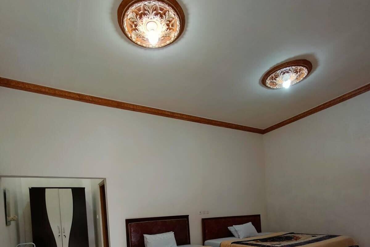 Ein Schlafzimmer mit zwei Betten, einem Sessel und einem Kleiderschrank.