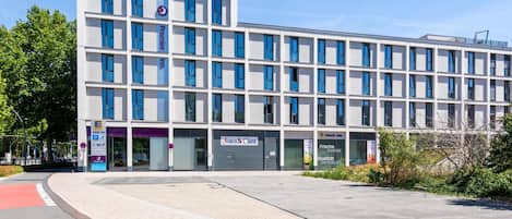Un bâtiment moderne à plusieurs étages, avec une enseigne Premier Inn bien visible et un centre d’enregistrement.