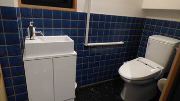 Un baño con un lavabo blanco, un inodoro y paredes con azulejos azules.