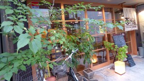 A storefront with a wooden facade, a bicycle rack, and a signboard.