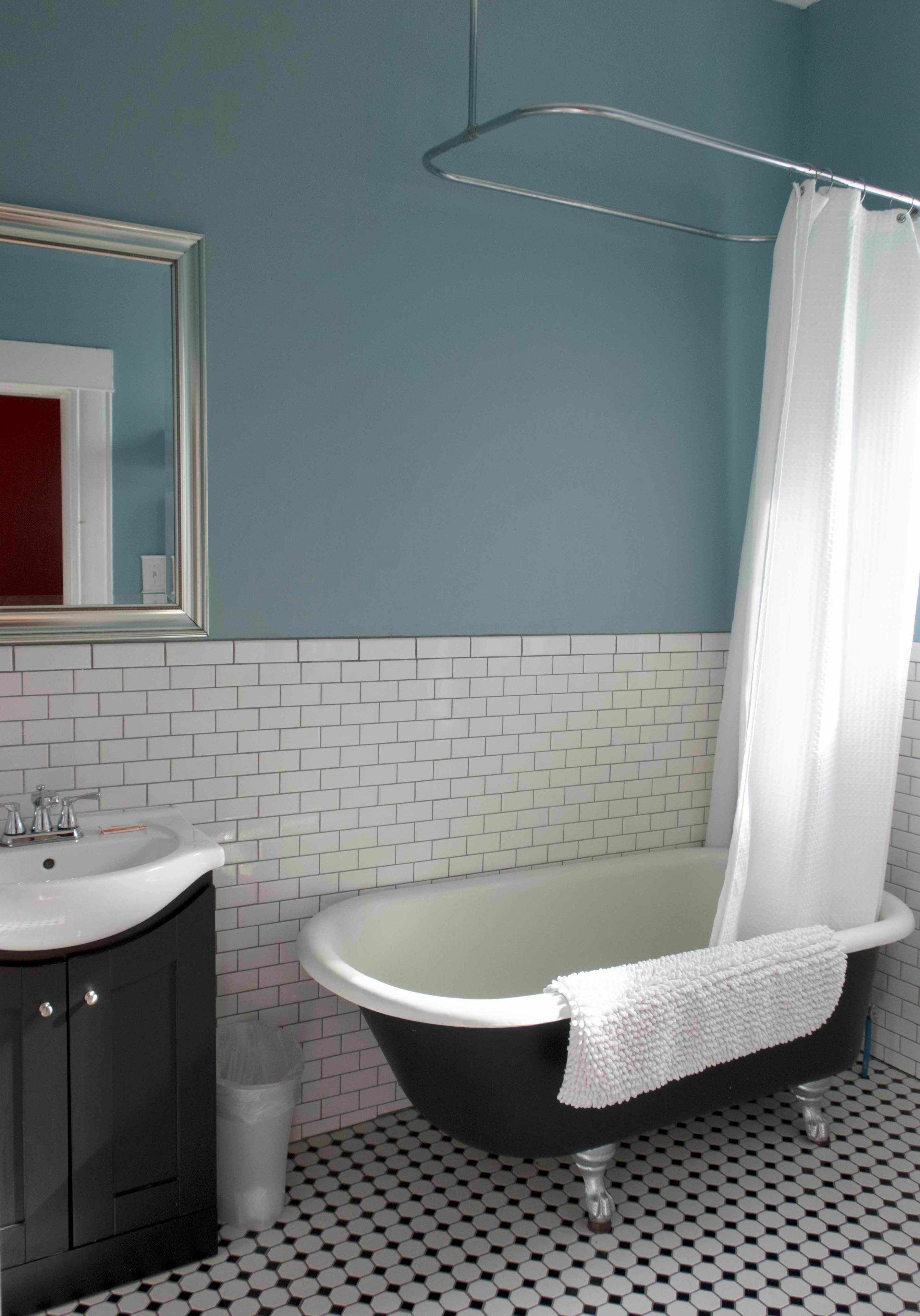 A bathroom with a bathtub, a sink, and a mirror.
