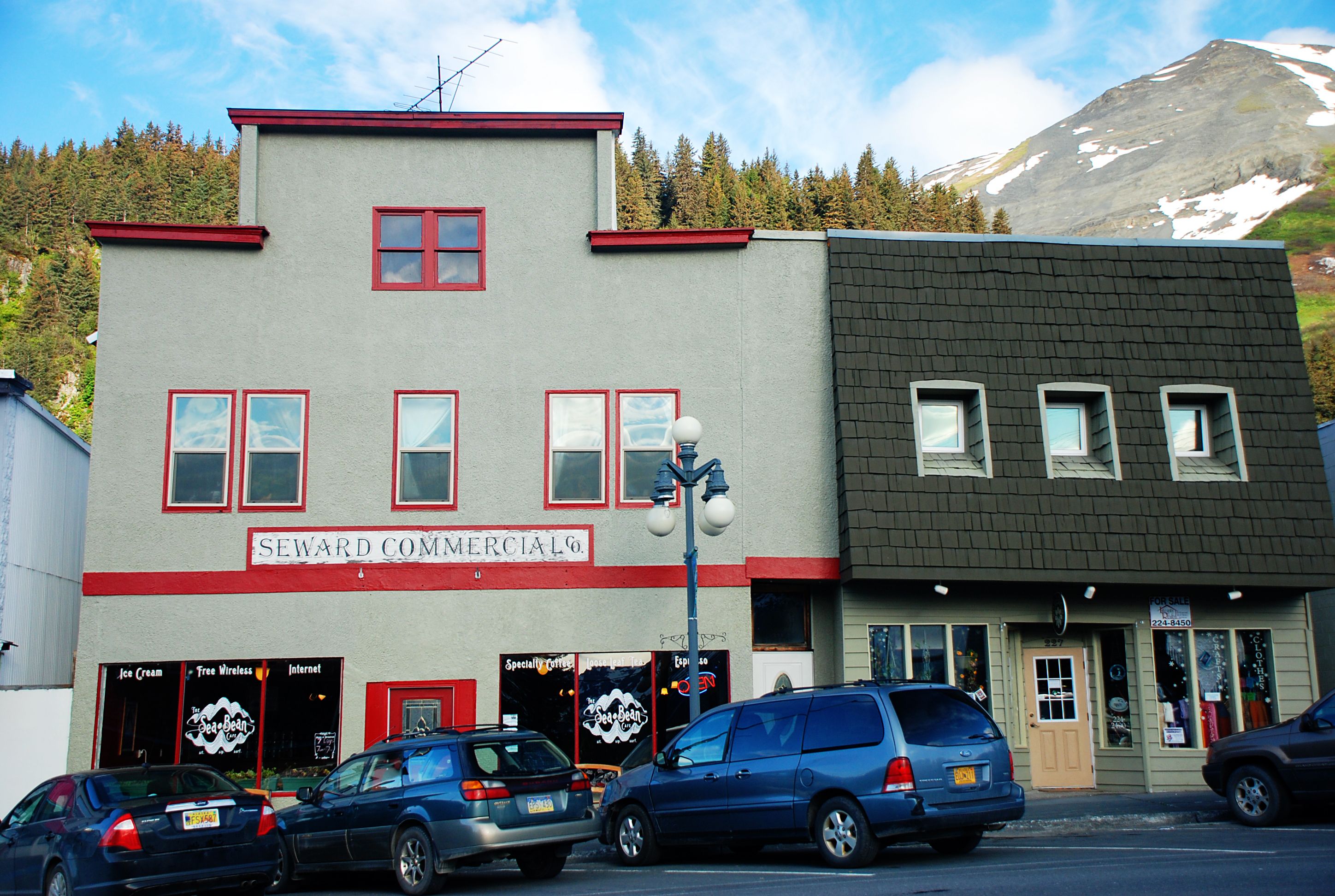 A two-story commercial building with a red and grey facade, multiple windows, and a sign that reads "SEWARD COMMERCIAL."