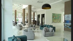A spacious lobby with striped sofas, a round coffee table, and a large hanging light fixture. - Porto Marina Mont Blanc Resort (Mangaratiba)