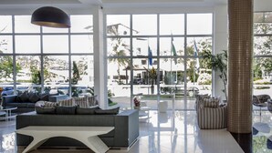 A spacious lobby with a modern sofa, a coffee table, and a large pillar. - Porto Marina Mont Blanc Resort (Mangaratiba)