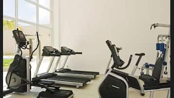 A gym with treadmills, elliptical machines, and a stationary bike.