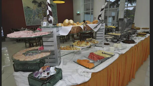 A buffet with various food items and a large painting on the wall. - Porto Marina Mont Blanc Resort (Mangaratiba)